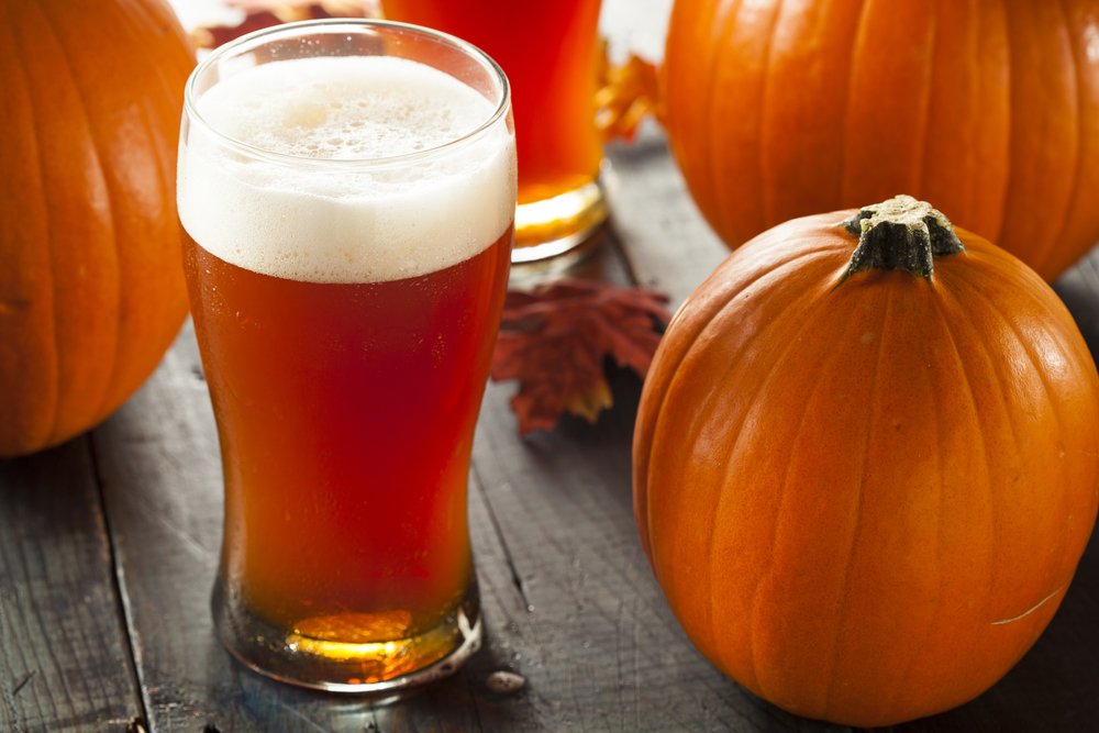 pint of beer next to a pumpkin